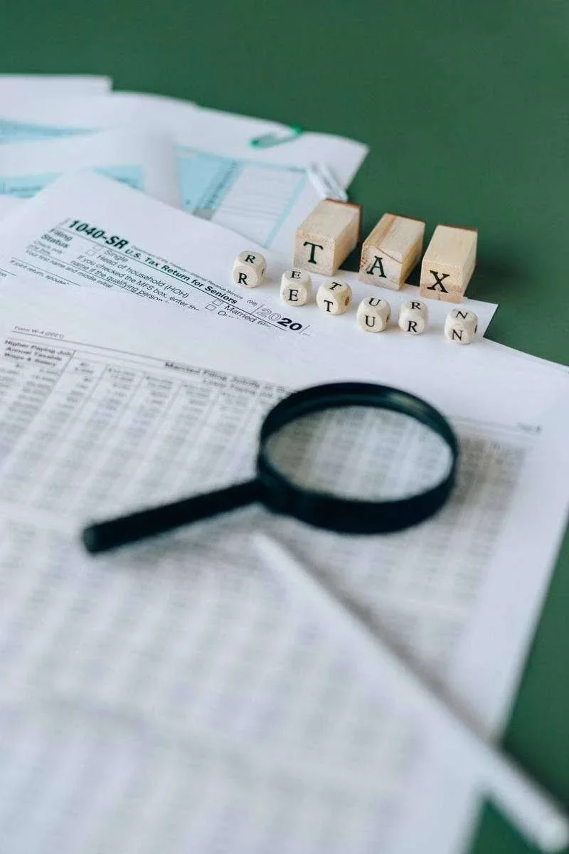 Formulário 1040-SR, blocos 'TAX', dados 'RETURN' e lupa sobre documentos fiscais