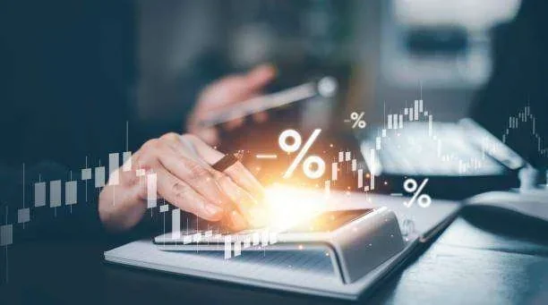 Mãos usando calculadora com gráficos financeiros e símbolos de porcentagem, incluindo negativos